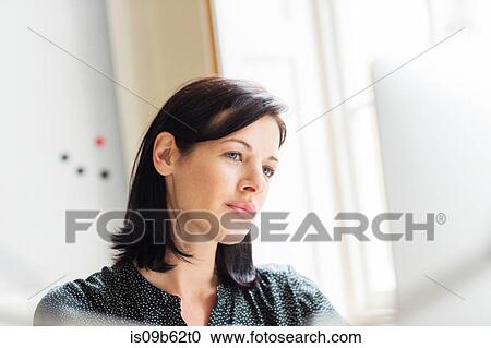 Stock Image - Female designer looking at computer in creative studio. Fotosearch