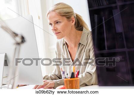 Female designer typing at desktop computer in creative studio View Large Photo Image Stock Photo - Female designer typing at desktop computer in creative studio. Fotosearch
