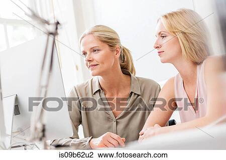 Female designers looking at desktop computer in creative studio View Large Photo Image Stock Image - Female designers looking at desktop computer in creative studio. Fotosearch