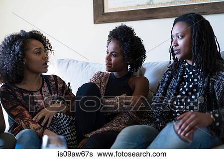Stock Photograph - Female friends relaxing at home. Fotosearch