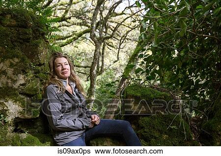 Female hiker sitting on moss covered woodland rocks, Spain View Large Photo Image Stock Photograph - Female hiker sitting on moss covered woodland rocks, Spain. Fotosearch