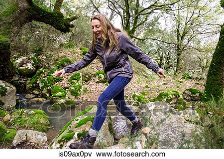 Female hiker stepping over woodland boulders, Spain View Large Photo Image Stock Photo - Female hiker stepping over woodland boulders, Spain. Fotosearch
