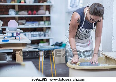Female potter cleaning pottery wheel in workshop View Large Photo Image Stock Image - Female potter cleaning pottery wheel in workshop. Fotosearch