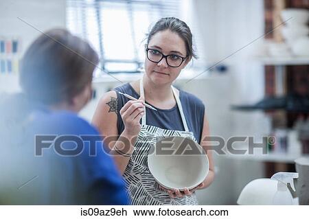 Female potter explaining finishing tool for bowl to trainee in workshop View Large Photo Image Stock Image - Female potter explaining finishing tool for bowl to trainee in workshop. Fotosearch