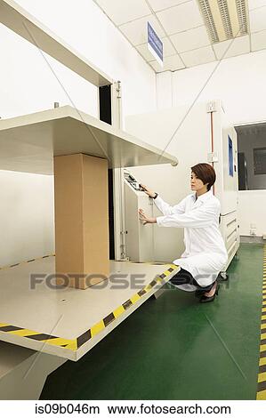 Picture - Female technician operating packaging machine in printing and packaging factory, China. Fotosearch