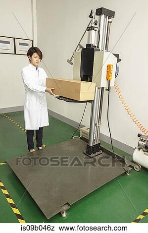 Female technician placing cardboard box on packaging machine in printing and packaging factory, China View Large Photo Image Stock Photo - Female technician placing cardboard box on packaging machine in printing and packaging factory, China. Fotosearch
