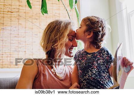 Stock Image - Female toddler kissing mother on forehead. Fotosearch