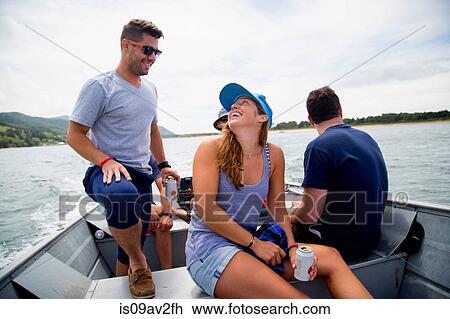 Stock Image - Five adult friends drinking beer on fishing boat at Nehalem Bay, Oregon, USA. Fotosearch