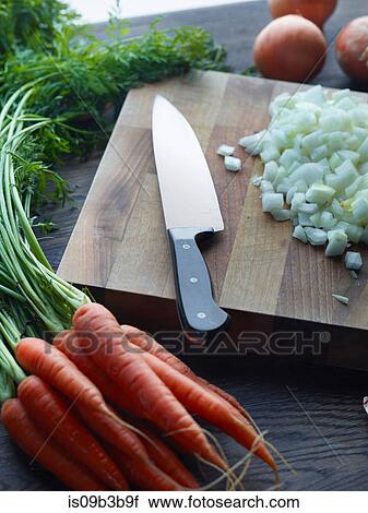 Stock Image - Fresh carrots with onions chopped on cutting board. Fotosearch