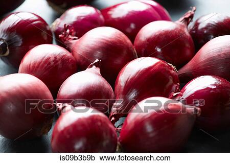 Stock Image - Fresh whole red onions on table. Fotosearch