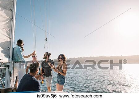 Stock Photograph - Friends chatting on sailboat, San Diego Bay, California, USA. Fotosearch