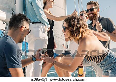 Friends having fun on sailboat View Large Photo Image Stock Image - Friends having fun on sailboat. Fotosearch