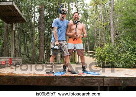 Friends wearing snorkels and swimming flippers on jetty, Niceville, Florida, USA View Large Photo Image Stock Photo - Friends wearing snorkels and swimming flippers on jetty, Niceville, Florida, USA. Fotosearch