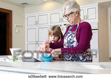 Girl and grandmother mixing cake at kitchen counter View Large Photo Image Stock Photo - Girl and grandmother mixing cake at kitchen counter. Fotosearch