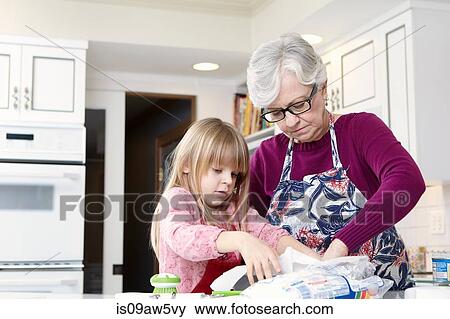 Girl and grandmother preparing greaseproof paper View Large Photo Image Stock Photo - Girl and grandmother preparing greaseproof paper. Fotosearch