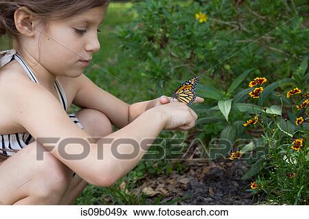 Stock Photo - Girl crouching holding monarch butterfly. Fotosearch