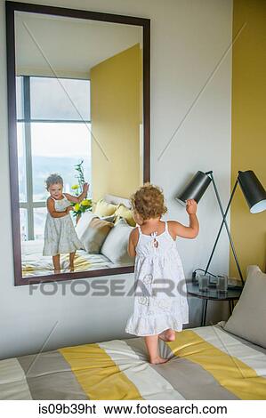 Girl dancing in front of mirror in bedroom View Large Photo Image Stock Photograph - Girl dancing in front of mirror in bedroom. Fotosearch