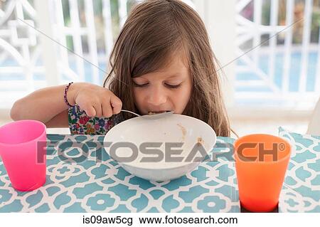 Girl eating breakfast from bowl with spoon View Large Photo Image Stock Image - Girl eating breakfast from bowl with spoon. Fotosearch