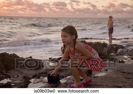 Girl filling toy bucket on beach at sunrise, Blowing Rocks Preserve, Jupiter Island, Florida, USA View Large Photo Image Stock Image - Girl filling toy bucket on beach at sunrise, Blowing Rocks Preserve, Jupiter Island, Florida, USA. Fotosearch