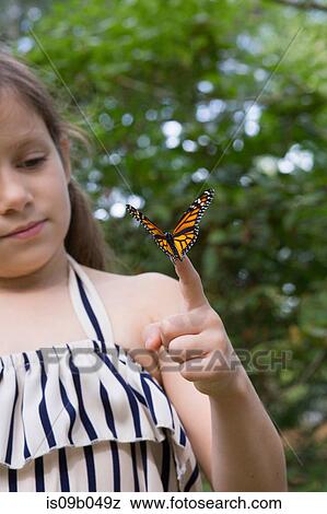 Girl holding monarch butterfly on finger View Large Photo Image Stock Photo - Girl holding monarch butterfly on finger. Fotosearch