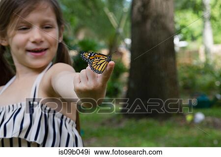 Girl holding monarch butterfly on finger smiling View Large Photo Image Stock Image - Girl holding monarch butterfly on finger smiling. Fotosearch