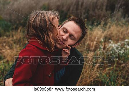 Girl kissing father on cheek in field View Large Photo Image Stock Photography - Girl kissing father on cheek in field. Fotosearch