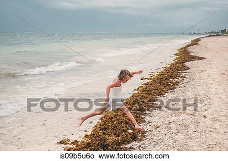 Girl playing on beach, Cancun, Mexico View Large Photo Image Picture - Girl playing on beach, Cancun, Mexico. Fotosearch