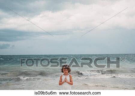 Picture - Girl praying on beach, Cancun, Mexico. Fotosearch