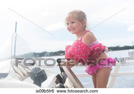 Stock Photograph - Girl steering speed boat smiling, Shalimar, Florida, USA. Fotosearch