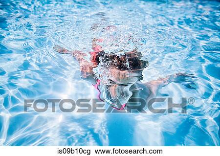 Girl swimming underwater in sunlit swimming pool View Large Photo Image Stock Image - Girl swimming underwater in sunlit swimming pool. Fotosearch