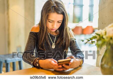 Stock Photograph - Girl texting on smartphone. Fotosearch