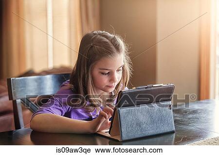 Girl using wireless digital tablet at home View Large Photo Image Stock Image - Girl using wireless digital tablet at home. Fotosearch
