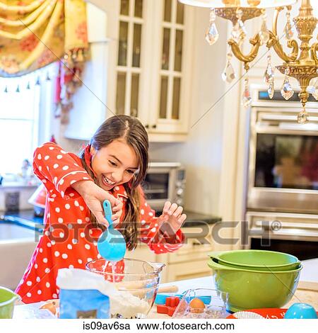 Girl wearing pyjamas at kitchen counter using measuring spoon smiling View Large Photo Image Stock Image - Girl wearing pyjamas at kitchen counter using measuring spoon smiling. Fotosearch