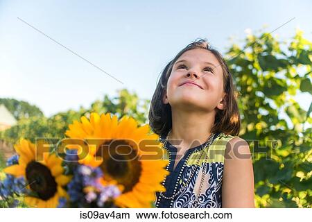 Picture - Girl with bunch of flowers in vineyard. Fotosearch