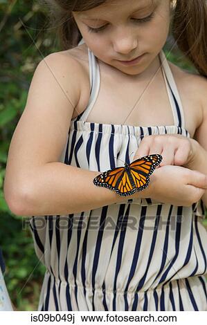 Girl with monarch butterfly on arm View Large Photo Image Stock Image - Girl with monarch butterfly on arm. Fotosearch