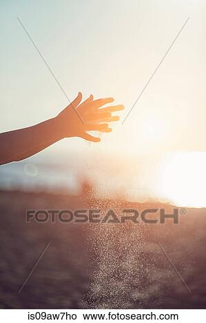 Girls hands sprinkling sand on beach at sunset View Large Photo Image Picture - Girls hands sprinkling sand on beach at sunset. Fotosearch