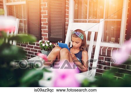 Girls on porch in rocking chair using digital tablet View Large Photo Image Stock Image - Girls on porch in rocking chair using digital tablet. Fotosearch