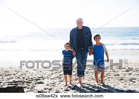 Grandfather with two grandsons, walking on beach, smiling View Large Photo Image Stock Photo - Grandfather with two grandsons, walking on beach, smiling. Fotosearch