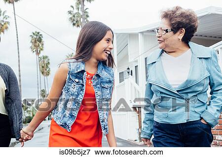 Grandmother and granddaughter walking in street View Large Photo Image Stock Photo - Grandmother and granddaughter walking in street. Fotosearch