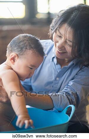 Grandmother bathing grandson in tub View Large Photo Image Picture - Grandmother bathing grandson in tub. Fotosearch