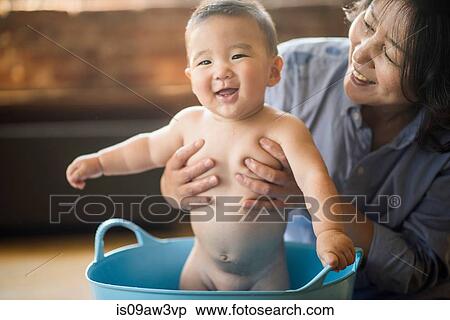 Stock Photography - Grandmother bathing grandson in tub. Fotosearch