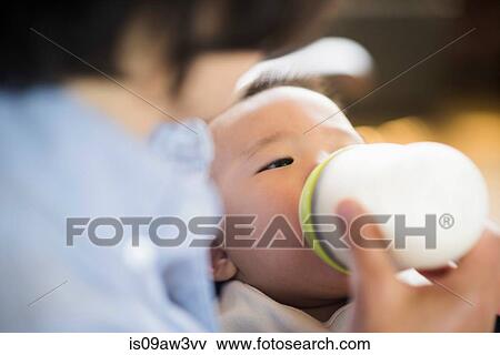 Grandmother feeding milk to grandson View Large Photo Image Stock Photo - Grandmother feeding milk to grandson. Fotosearch