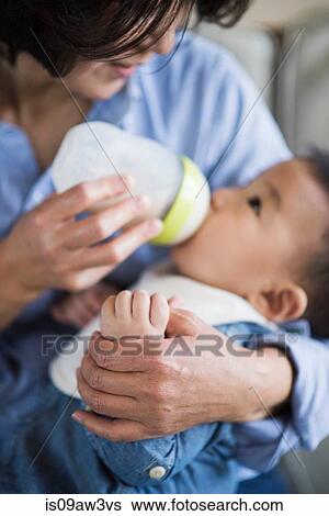 Grandmother feeding milk to grandson View Large Photo Image Stock Photograph - Grandmother feeding milk to grandson. Fotosearch