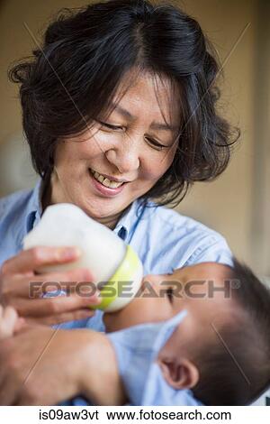 Grandmother feeding milk to grandson View Large Photo Image Stock Photograph - Grandmother feeding milk to grandson. Fotosearch