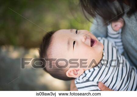 Stock Image - Grandmother playing with grandson outdoors. Fotosearch