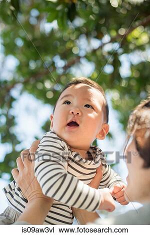 Stock Image - Grandmother playing with grandson outdoors. Fotosearch