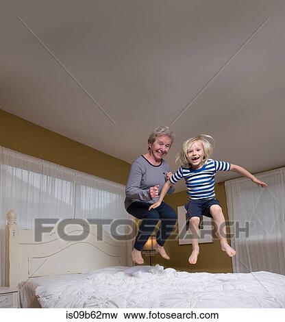 Grandson and grandmother jumping on bed View Large Photo Image Stock Photo - Grandson and grandmother jumping on bed. Fotosearch