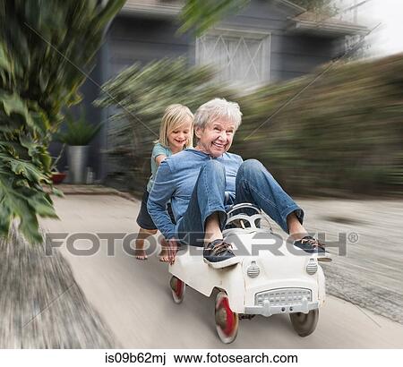 Grandson pushing grandmother on his toy car View Large Photo Image Stock Image - Grandson pushing grandmother on his toy car. Fotosearch
