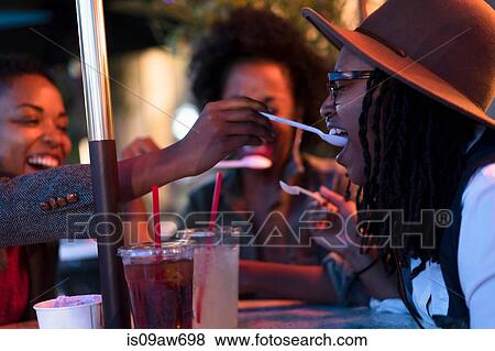 Stock Photo - Group of female friends, having drinks at cafe, outdoors. Fotosearch