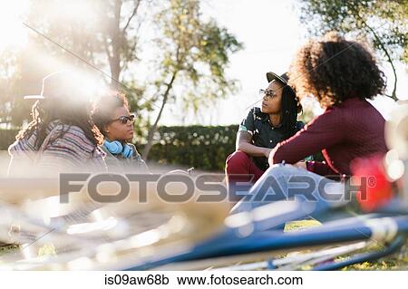 Group of female friends relaxing in park View Large Photo Image Stock Image - Group of female friends relaxing in park. Fotosearch